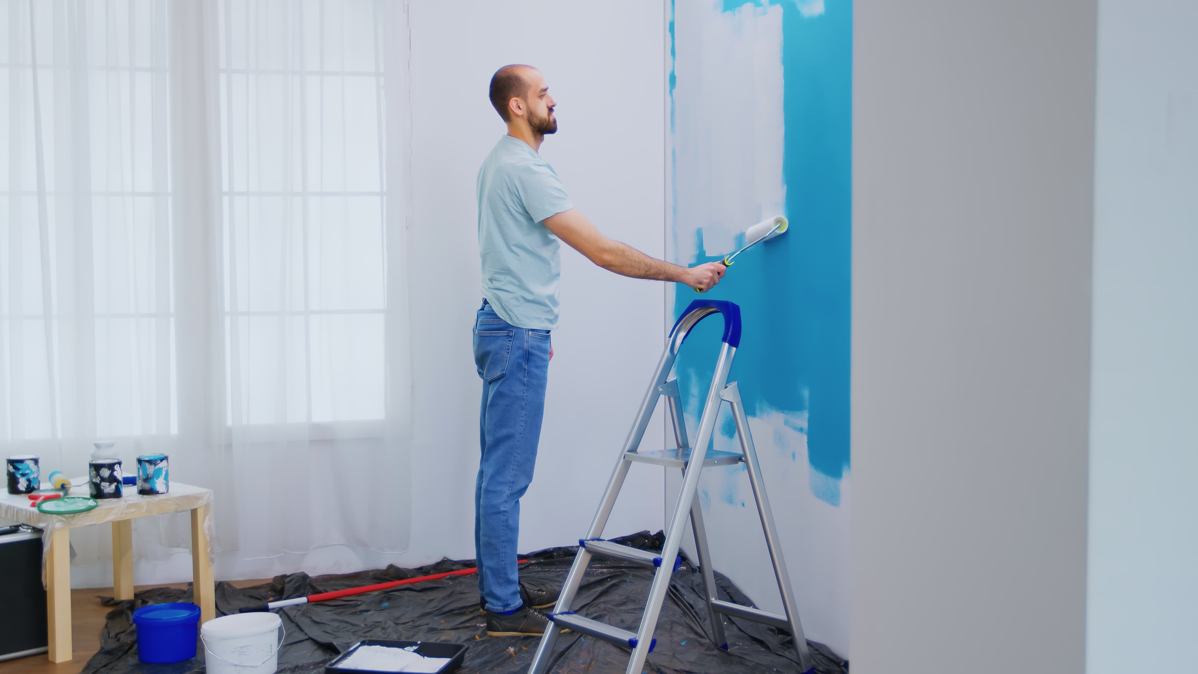 Professional painter rolling a fresh coat on an interior wall